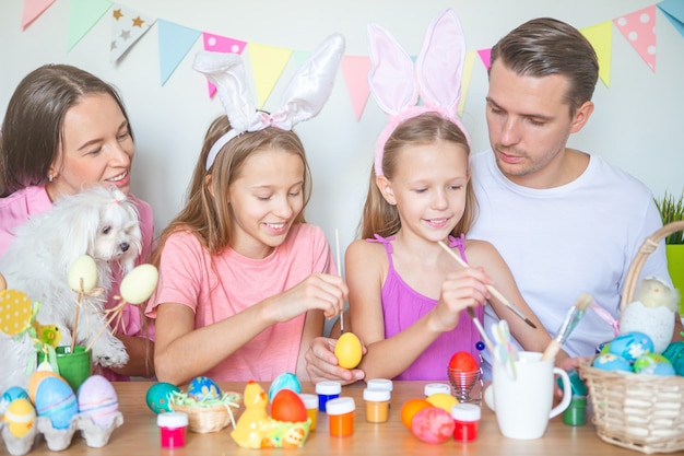 Madre e figlia piccola pittura uova. Famiglia felice che prepara per la Pasqua.