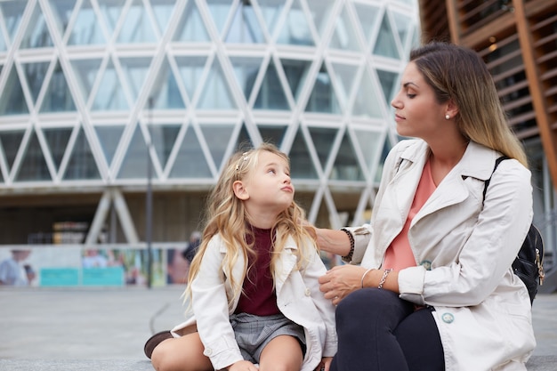 Madre e figlia ridono sinceramente. Stile di famiglia, emozioni vere, buona giornata.