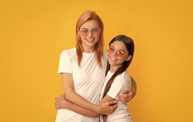 Madre e figlia si abbracciano in occhiali da sole bellezza e moda modello di moda femminile
