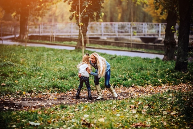 Madre e figlia si divertono nel parco autunnale