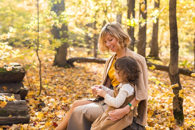 Madre e figlia si godono una bella giornata autunnale in un concetto di famiglia e bambini della stagione del parco