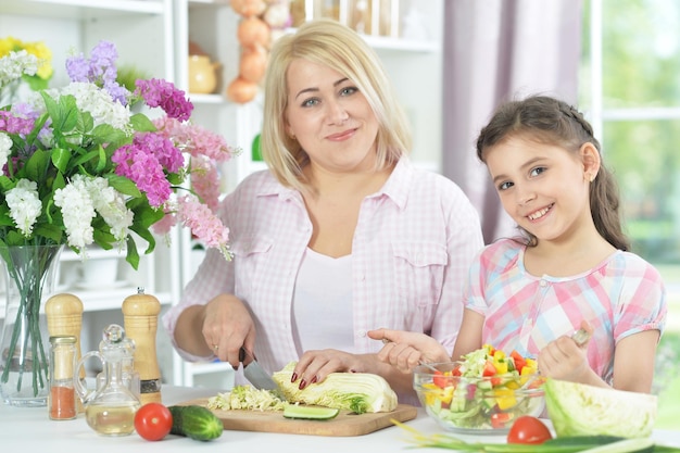 Madre e figlia sorridenti che cucinano insieme alla cucina