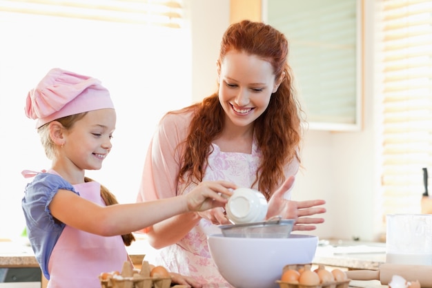 Madre e figlia sorridenti che preparano insieme pasta