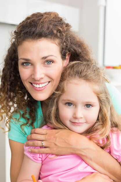 Madre e figlia sorridenti che stringono a sé