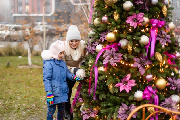 Madre e figlia sorridenti vicino all'albero di Natale