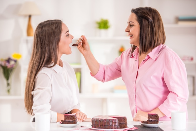 Madre e figlia teenager a casa per mangiare dessert.