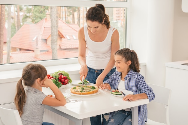 Madre e figlie che mangiano cibo sano