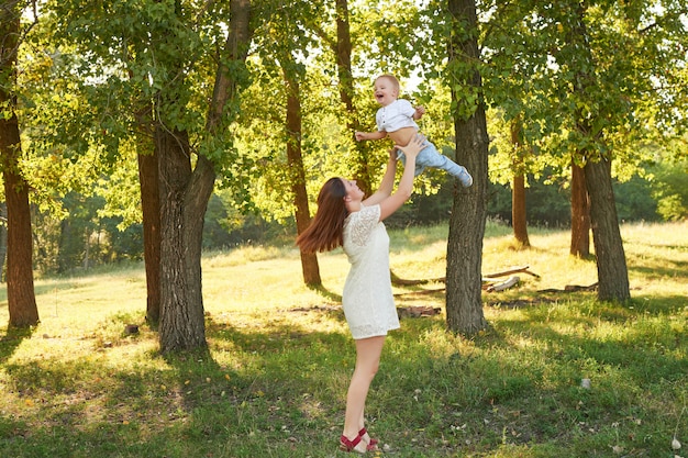 madre e figlio a piedi nel parco in estate al tramonto