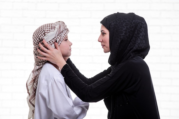 Madre e figlio arabi in posa al chiuso.