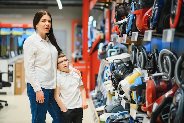 Madre e figlio che acquistano un aspirapolvere elettrico sorridente