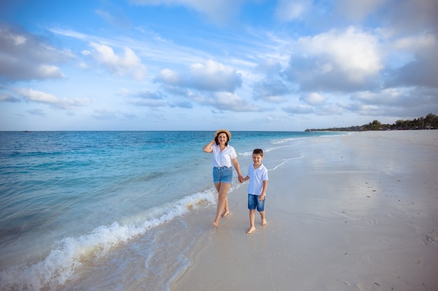 madre e figlio che camminano lungo l'oceano