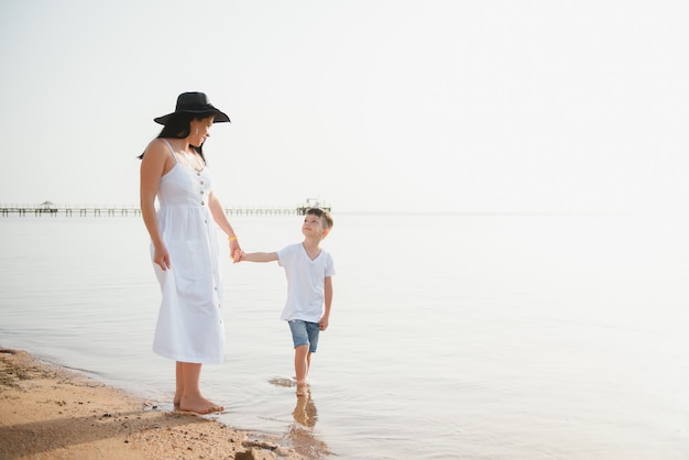 Madre e figlio che camminano sulla spiaggia