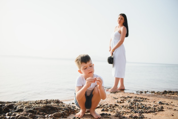 Madre e figlio che camminano sulla spiaggia