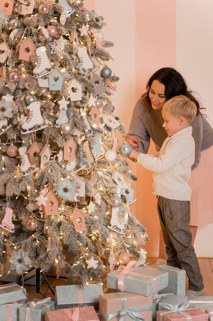 Madre e figlio che decorano il concetto dell'albero di Natale