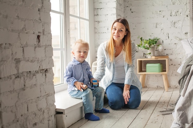 Madre e figlio che giocano a casa. Donna e bambino che indossa un panno di jeans blu