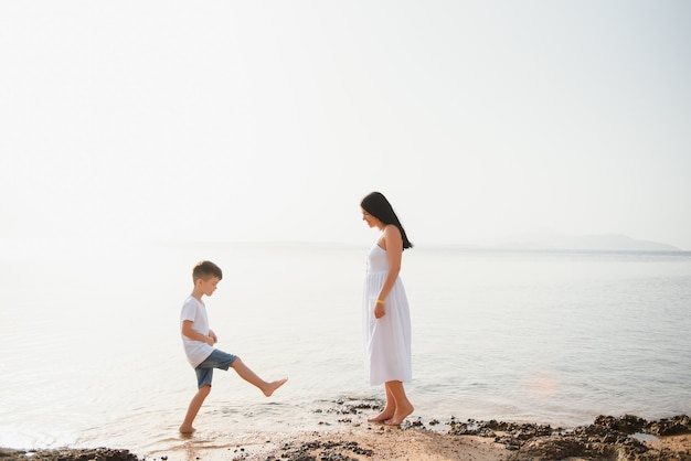 Madre e figlio che giocano sulla spiaggia durante il giorno.