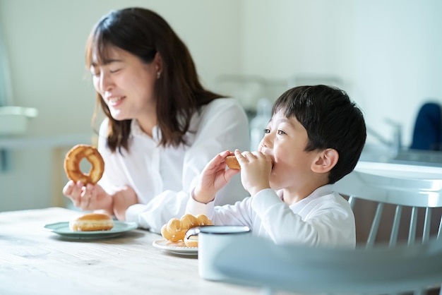 Madre e figlio che mangiano ciambelle