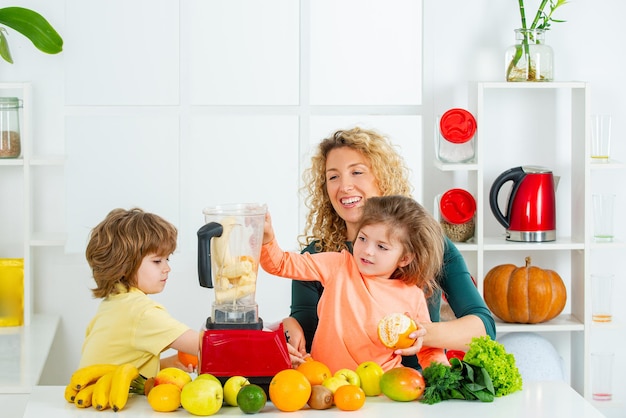 Madre e figlio che preparano il pranzo da una famiglia felice di verdure fresche che si godono un pasto sano insieme a...