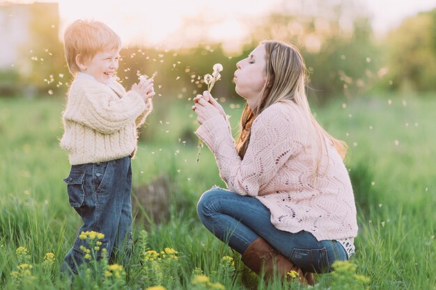 Madre e figlio che soffia tarassaco