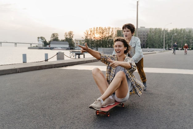 Madre e figlio che trascorrono il loro tempo libero facendo skateboard all'aperto