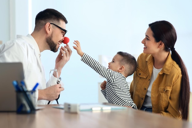 Madre e figlio che visitano il pediatra in ospedale Dottore che gioca con il ragazzino