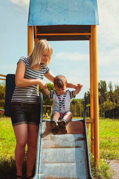 Madre e figlio giocano nel parco e ridono durante una passeggiata estiva in una giornata di sole. Vacanza in famiglia