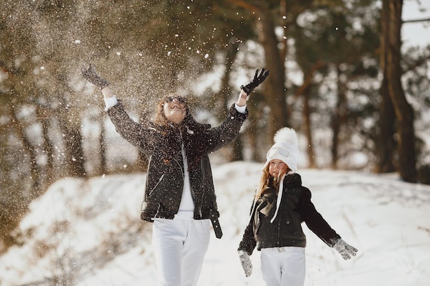 Madre e figlio in abiti da inverno giocano nel parco invernale