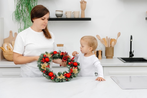 Madre e figlio in cucina con addobbi natalizi preparativi per la vigilia di capodanno