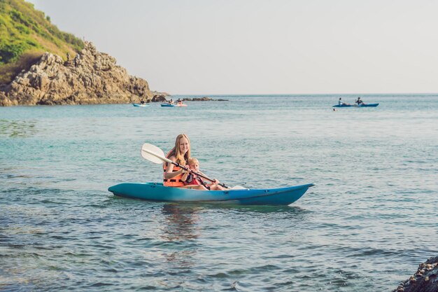 Madre e figlio in kayak all'oceano tropicale.