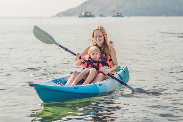 Madre e figlio in kayak nell'oceano tropicale