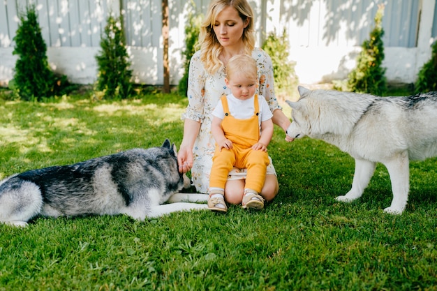 Madre e figlio in posa con due cani in giardino