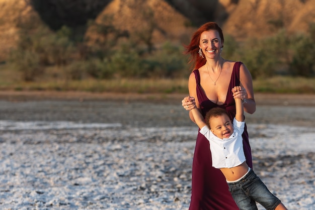 Madre e figlio piccolo che si divertono nella natura. Persone reali. Mamma e figlio del bambino che hanno un grande fine settimana. Famiglia di razza mista