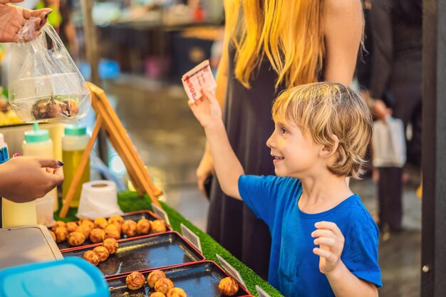 Madre e figlio sono turisti sul mercato alimentare asiatico di Walking Street