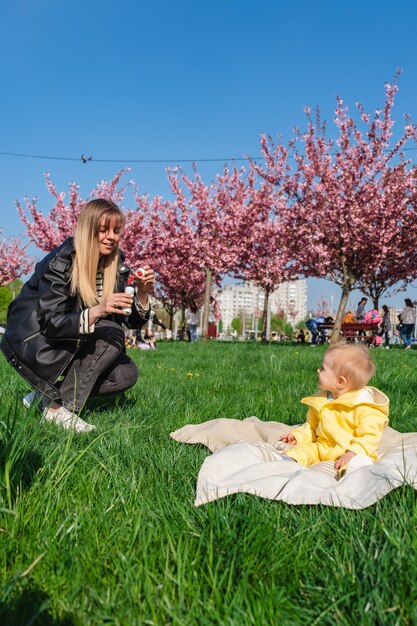 Madre e figlio sorridenti che si godono del tempo di qualità in un parco fiorito