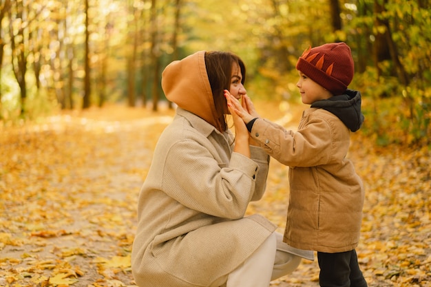 Madre e figlio stanno camminando nella foresta autunnale attività all'aperto autunnale per la famiglia con bambini