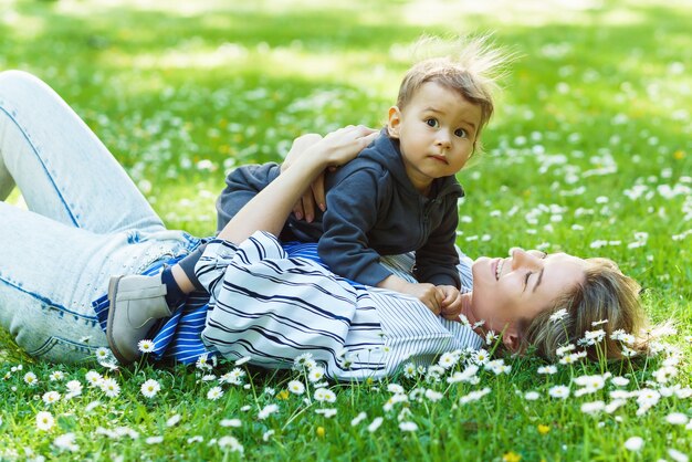 Madre e il suo bambino carino in un campo di camomilla