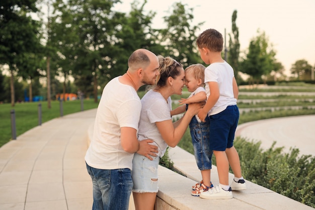 Madre e padre che giocano nel parco con i loro figli