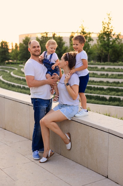 Madre e padre che giocano nel parco con i loro figli