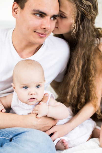 Madre e padre con bambino piccolo in un letto