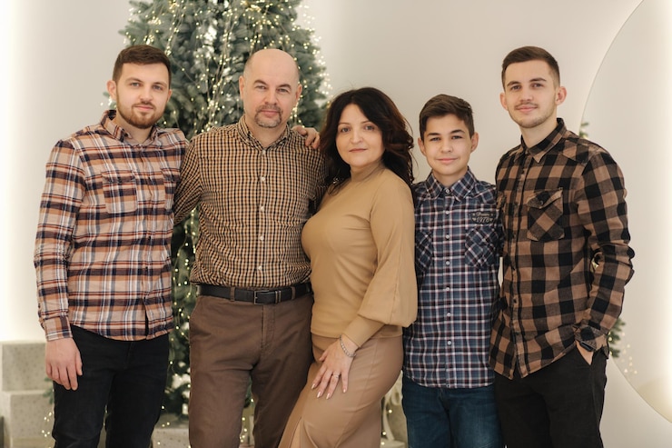 Madre e padre con i loro tre figli sorridono grande famiglia di quattro uomini e una donna natale feiry