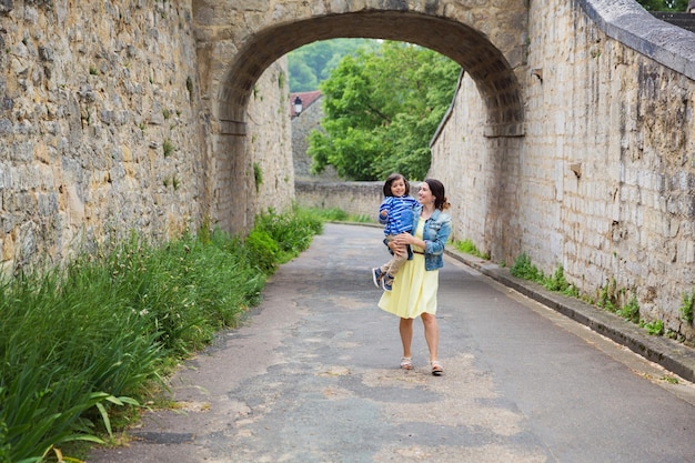 Madre e piccolo neonato bello che giocano all'aperto nella città vecchia