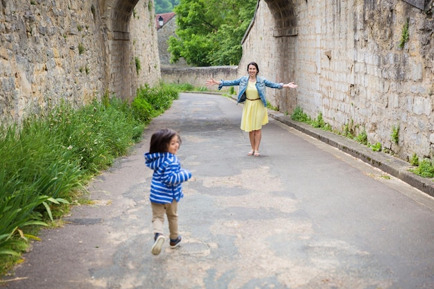 Madre e piccolo neonato bello orientale che giocano all'aperto nella città vecchia