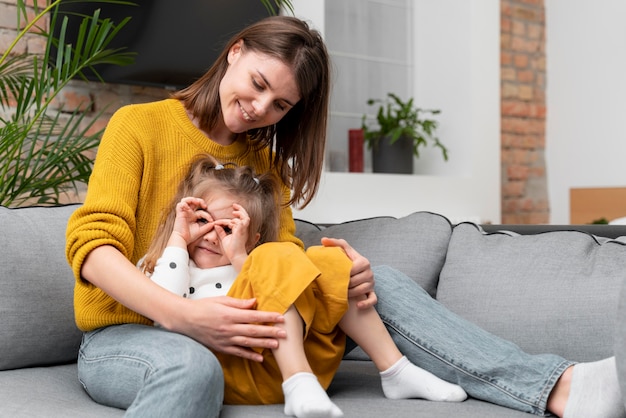 Madre e ragazza del colpo medio sul divano