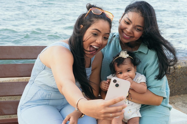 Madre e sorella che fanno un selfie con il suo bambino