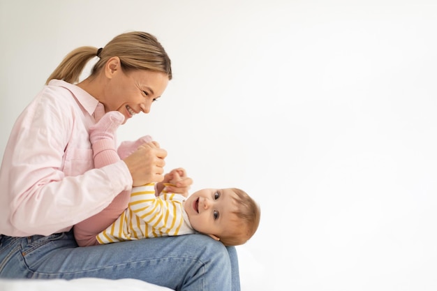 Madre europea amorevole che gioca con la figlia piccola che si prende cura del bambino che si gode il lato tenero del momento