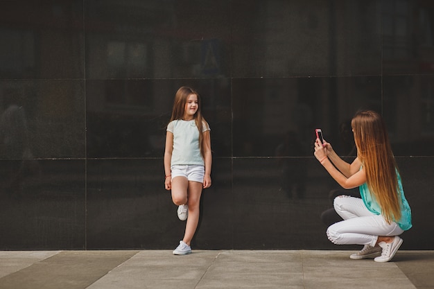 Madre felice che cattura bambino del ritratto sullo smartphone