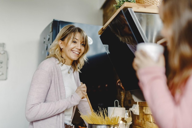 Madre felice che comunica con sua figlia mentre cucina in cucina