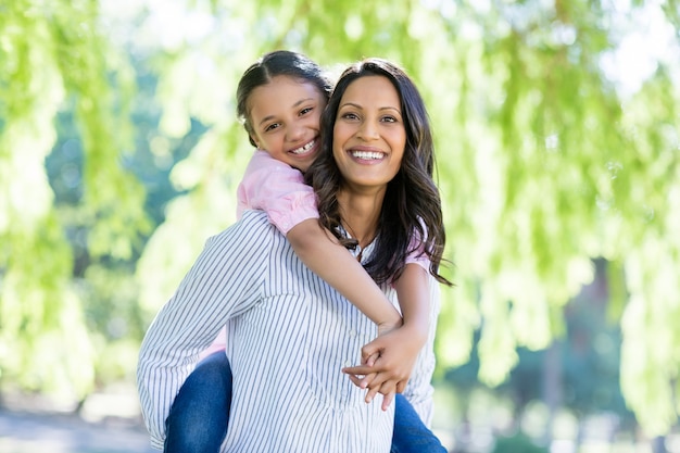 Madre felice che dà sulle spalle giro a sua figlia