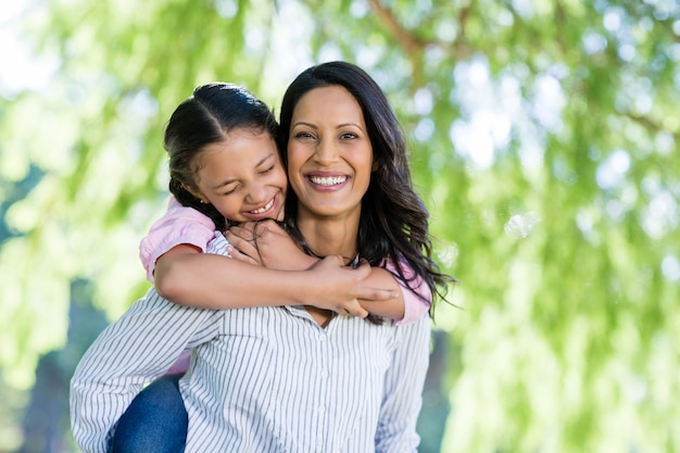 Madre felice che dà sulle spalle giro a sua figlia