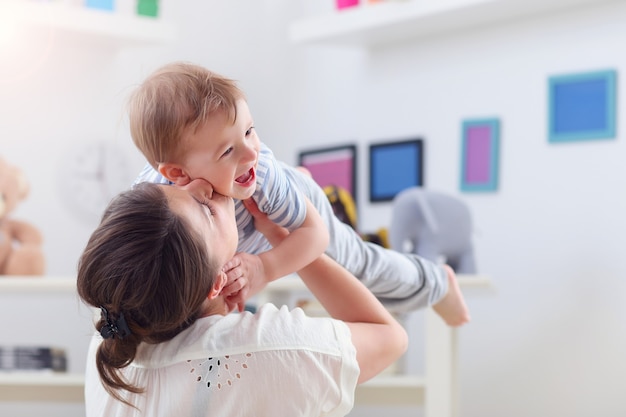 Madre felice che gioca con il bambino a casa